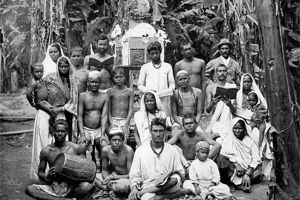 'Coolies at worship', Jamaica, c1905. Group portrait of Indian immigrants who came to the island as indentured workers. Illustration from Picturesque Jamaica, by Adolphe Duperly & Son, (England, c1905).