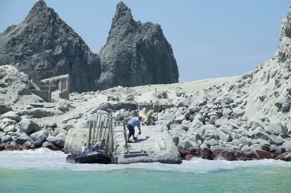 Tour guides evacuate tourists on a boat shortly after the volcano eruption on White Island