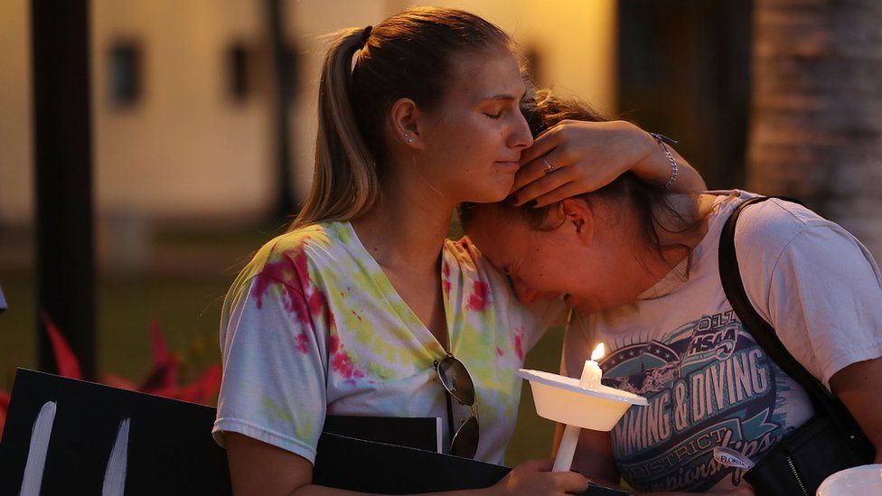 Two girls cry and comfort each other at Parkland vigil