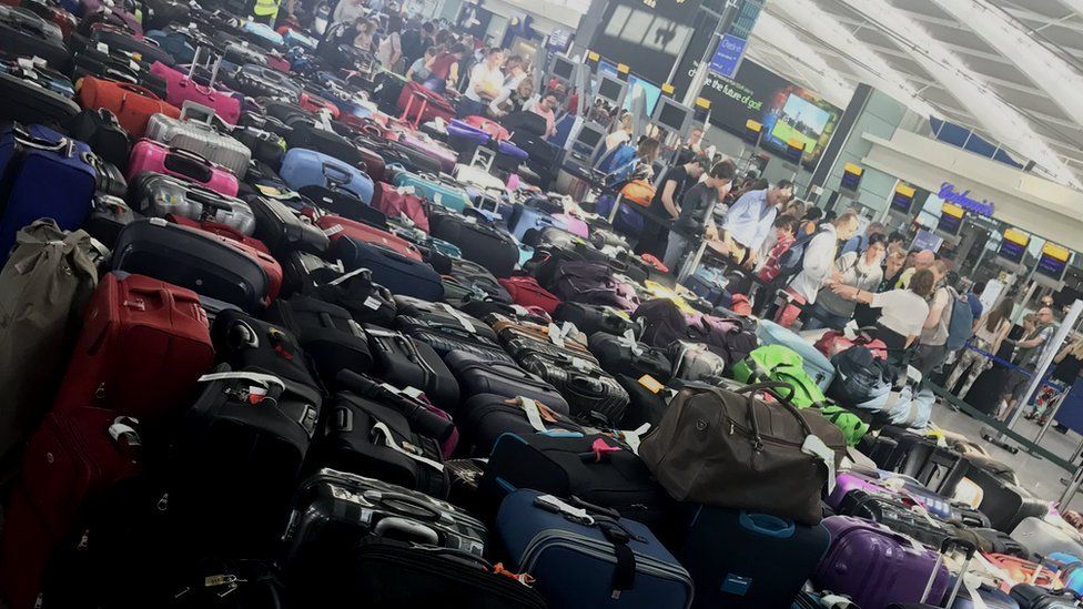 Piles of checked luggage on the floor in the Heathrow