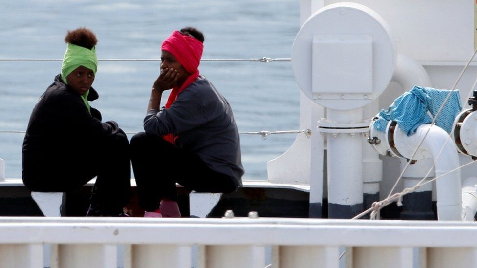 Two women sit on board ship