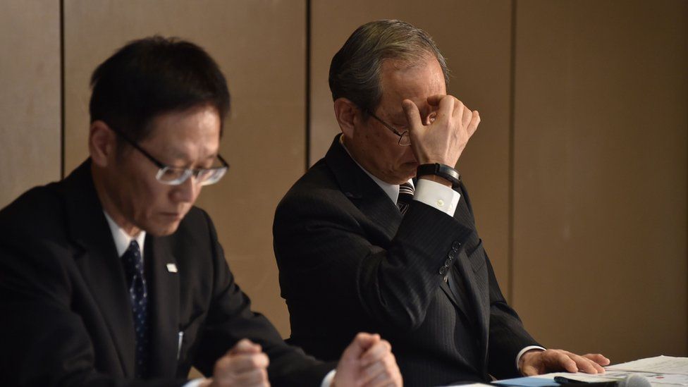 Toshiba Corp. President Satoshi Tsunakawa (R) reacts as he listens to questions during a press conference at the company's headquarters in Tokyo on December 27, 2016