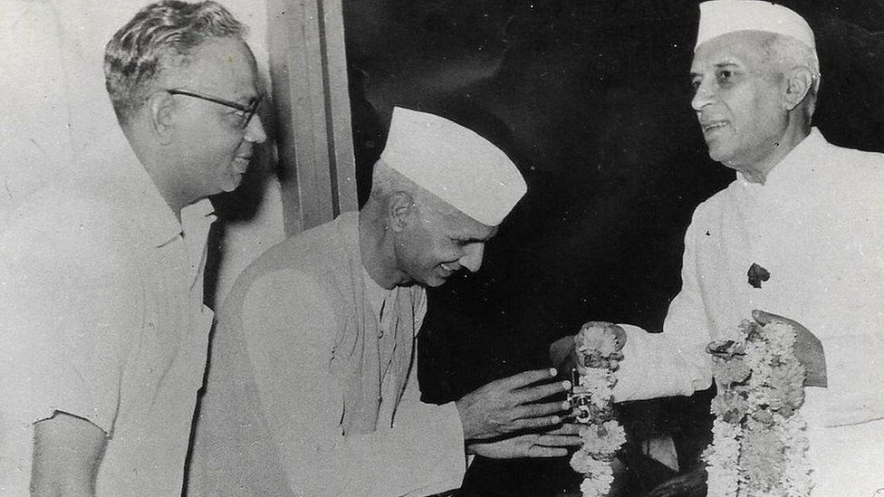 Saroj Lal's father Behari Lal Chanana (centre) receiving a floral garland from the first Prime Minister of India, Jawaharlal Nehru (right)