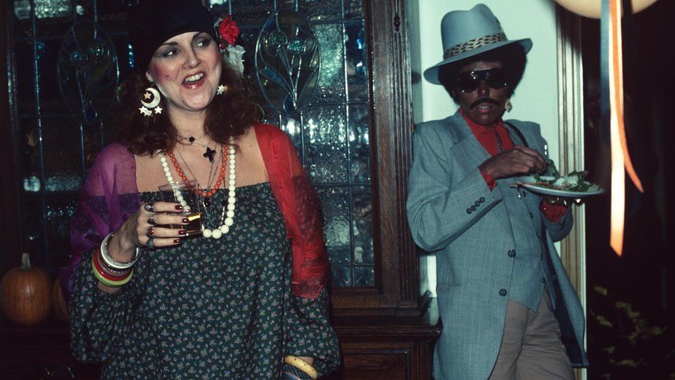Joni Mitchell (right), in blackface, at a party with Henry Diltz's wife