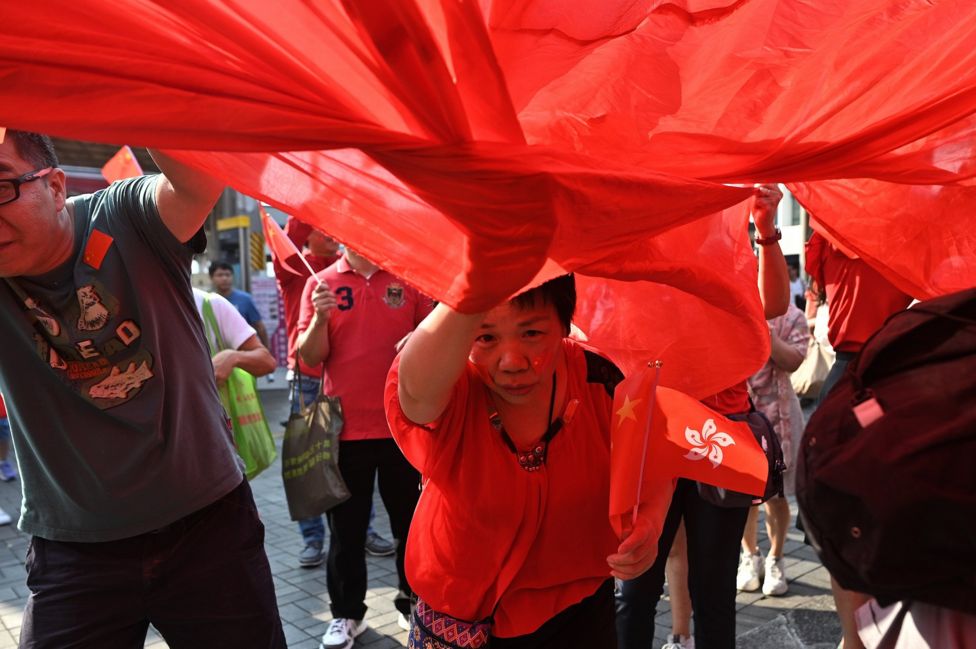 Một phụ nữ cầm cờ Hong Kong giữa cuộc biểu tình của người thân Bắc Kinh ở Hong Kong hôm 1/10, ngày kỷ niệm 70 năm cộng sản thống trị ở Trung Quốc