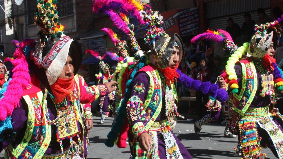 Richly adorned dancers parade through the streets of La Paz