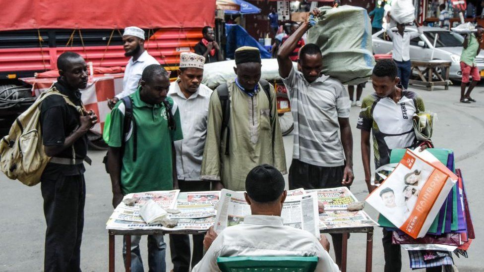 People look at newspapers without adhering to the rules of social distancing despite the confirmed COVID-19 coronavirus cases in Dar es Salaam, Tanzania, on 16 April 2020