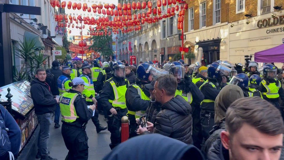 Police officers scuffle with counter protesters in London's Chinatown ahead of a pro-Palestinian protest march in London