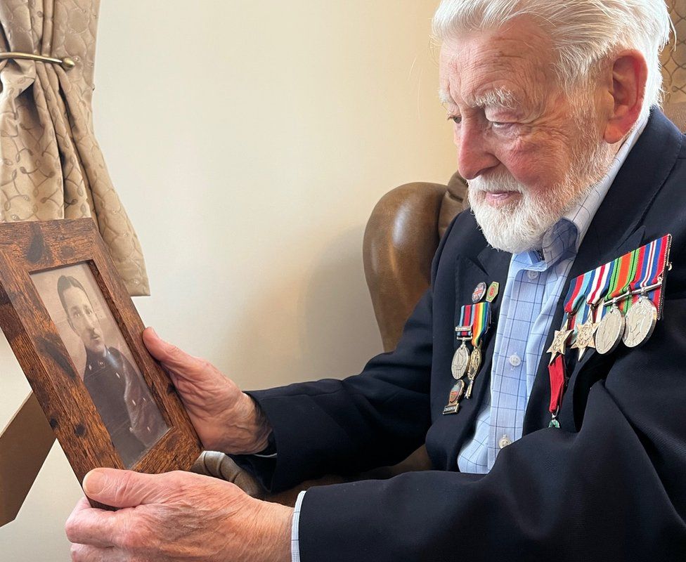 Les holding a photograph of Jack Grimsey killed in Normandy on 7 June 1944