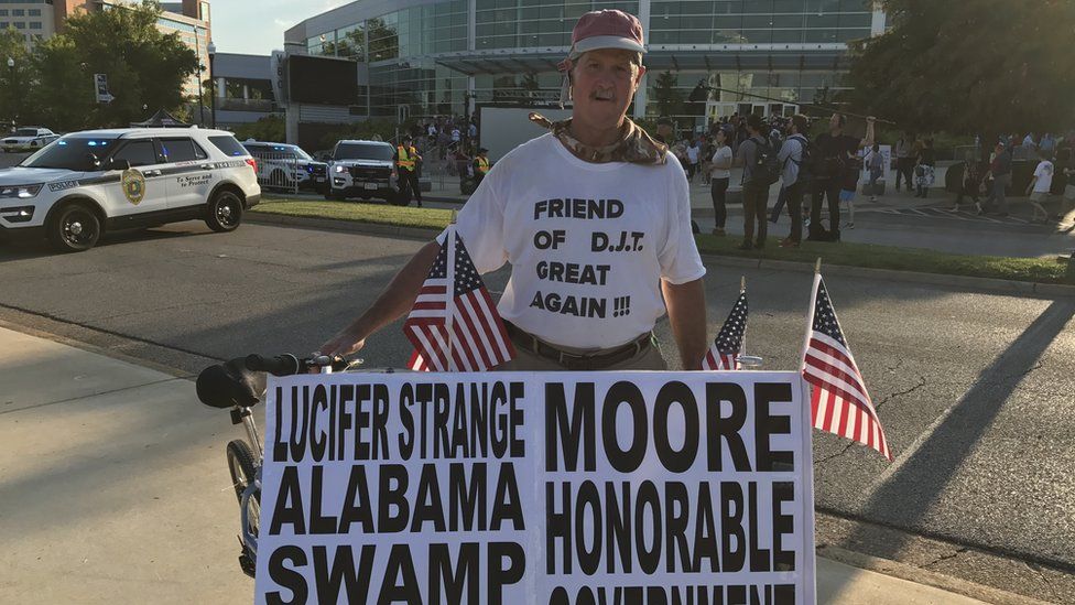 Peter Grove displays his pro-Moore campaign signs at the Donald Trump rally in Huntsville