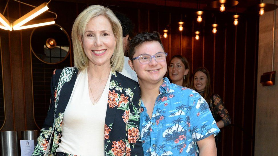 Sally Phillips with her son Olly, both wearing Hawaiian style shirts and smiling