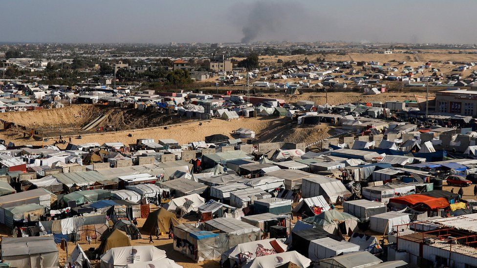 Smoke rises from the Khan Younis, as seen from makeshift camp for displaced Palestinians in Rafah, in the southern Gaza Strip (22 January 2024)