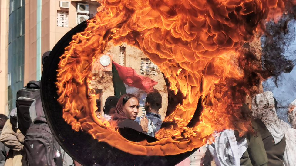 A demonstrator looks on from behind a flaming tyre during a protest demanding civilian rule in Omdurman, Sudan - Tuesday 4 January 2022