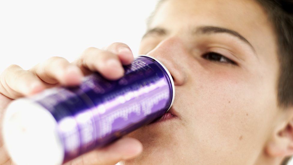 Teenage boy drinking from a can
