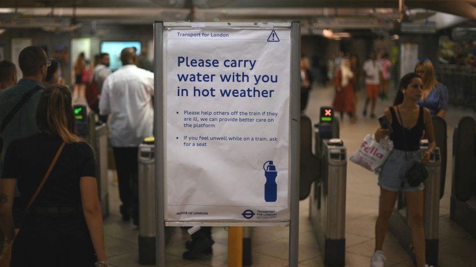 A sign advises commuters and travellers to carry water with them as they travel during the hot weather, at TfL's (Transport for London) Westminster Underground tube station in central London on July 16, 2022
