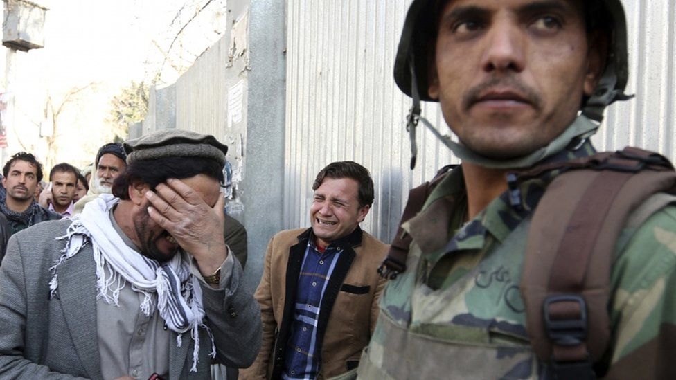 Afghans cry after an attack on a military hospital in Kabul, Afghanistan,