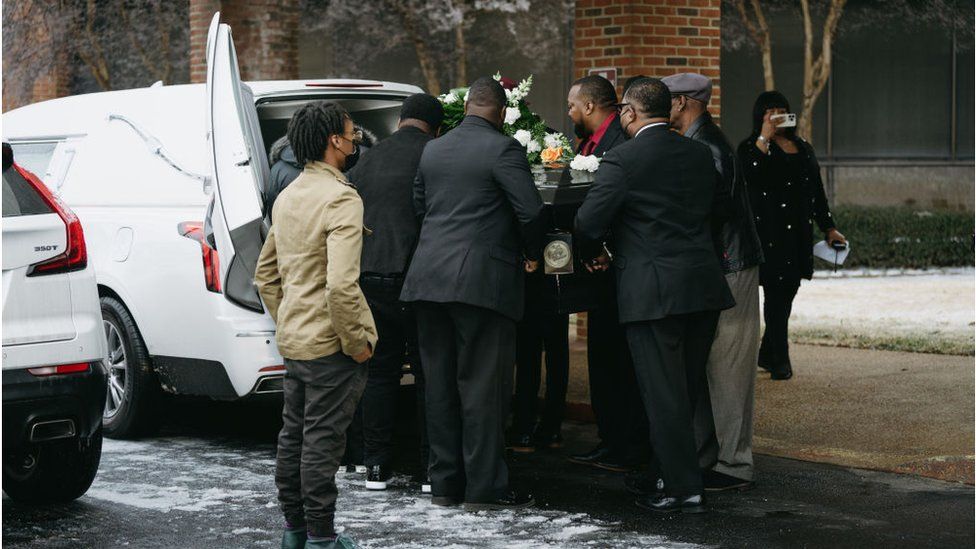 Nichols' casket coming out of a hearse