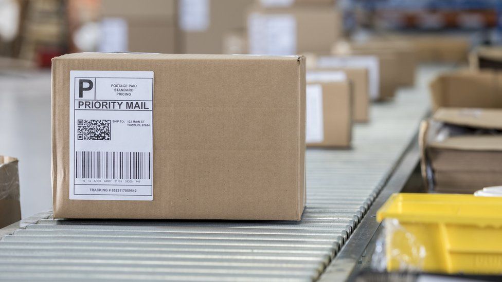A parcel sitting on a conveyor belt in a sorting office