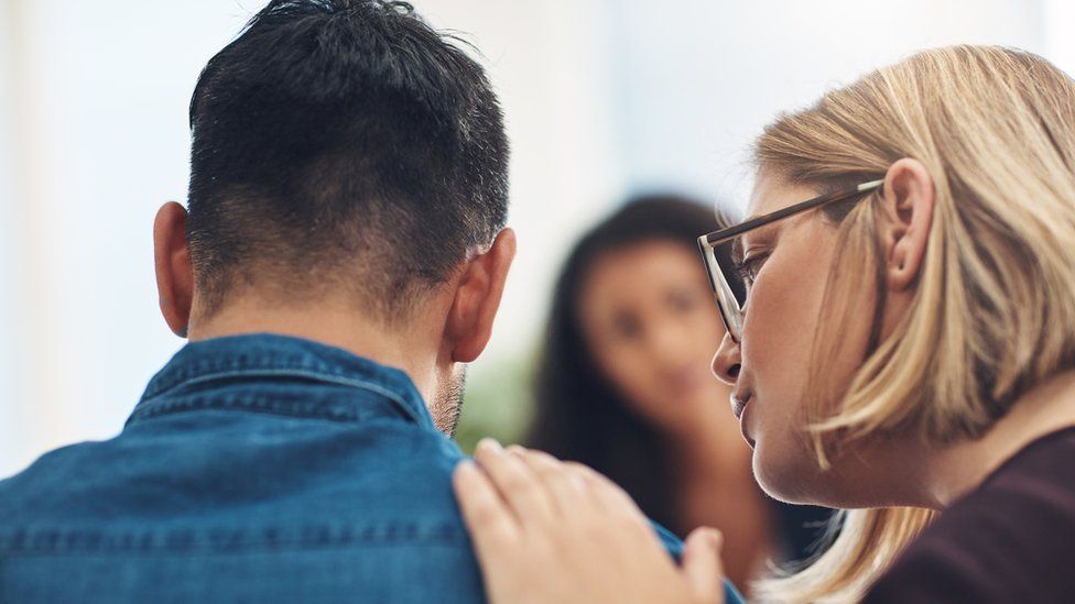 A woman comforting a man