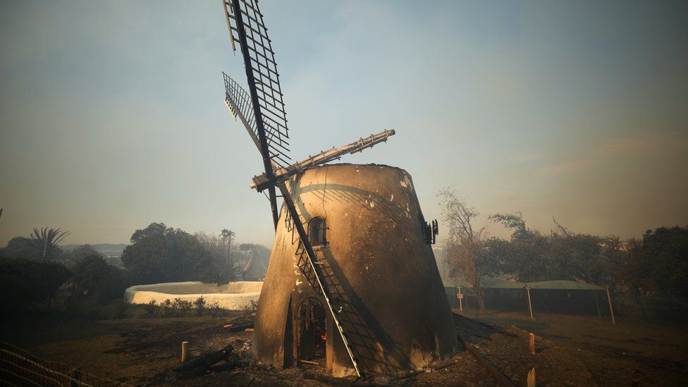 The historic Mostert's Mill smoulders as firefighters battle to contain a fire that broke out on the slopes of Table Mountain