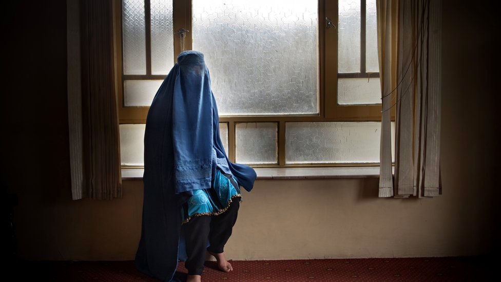 Woman covered with a burqa in a home