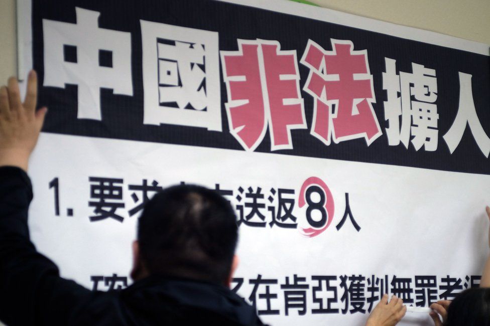 Workers paste a sign reading "China illegally abducts Taiwanese people" during a press conference organized by lawmakers from the Democratic Progressive Party (DPP) at Parliament in Taipei on 12 April 2016.