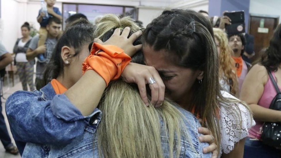 Victims' relatives and campaigners hug each other after a court ruling in Mendoza, Argentina. Photo: 25 November 2019