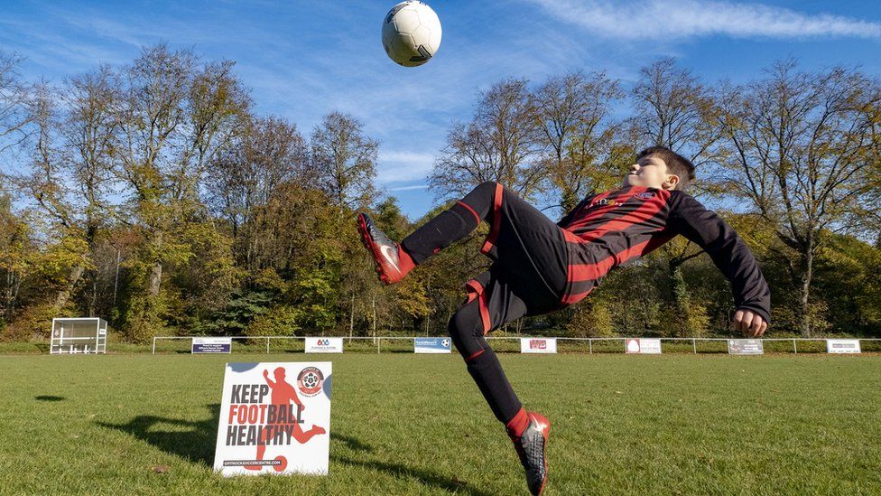 boy kicking football