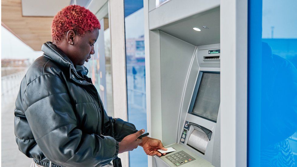 Woman using cash machine