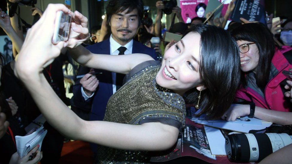 Yuko Takeuchi, pictured taking a selfie with fans, in 2018