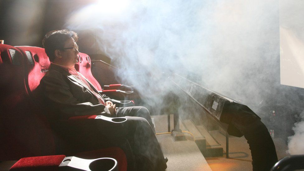 Man in cinema seat surrounded by fog in 4DX screening