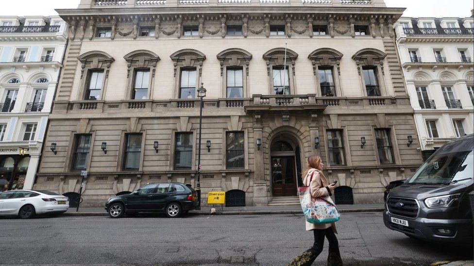 A person walks past the entrance to the Garrick club