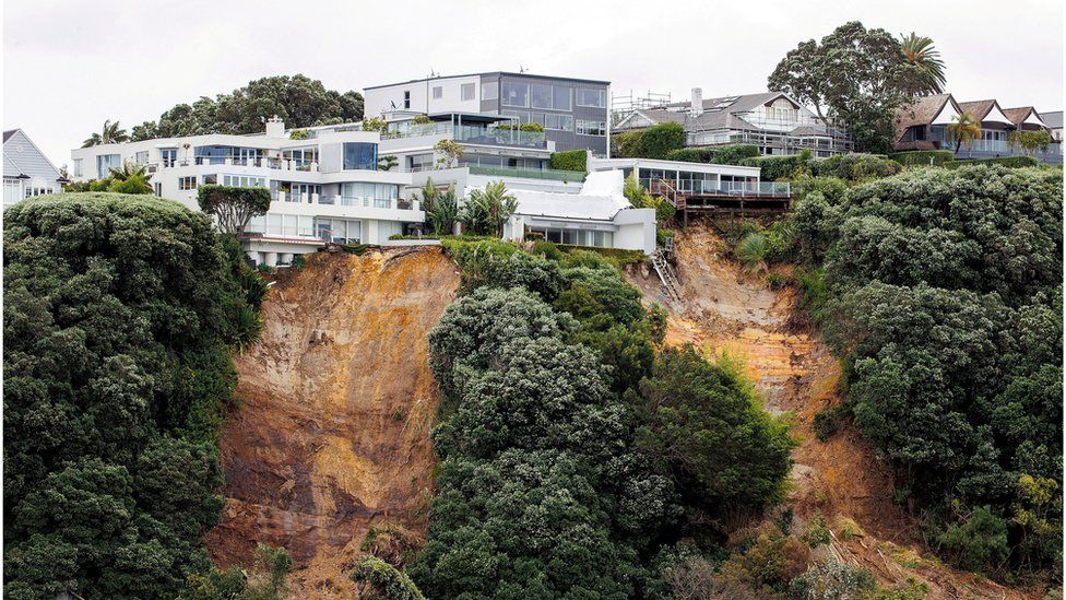 A house on top of a hill with a landslide below