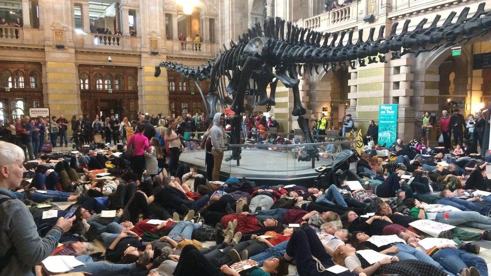 Wee Rebellion protesters stage a "die in" beneath Dippy the Dinosaur at Kelvingrove Art Gallery and Museum in Glasgow