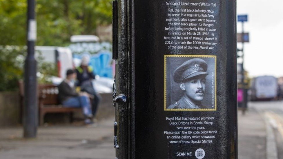 A black postbox featuring an image of Second Lieutenant Walter Tull in Byres Road, Glasgow