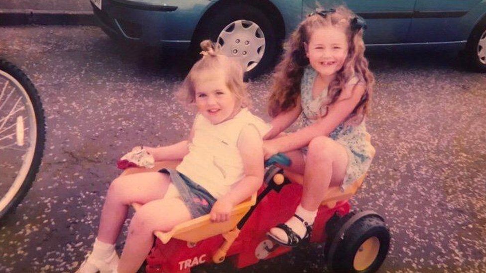 two girls sitting on go-cart