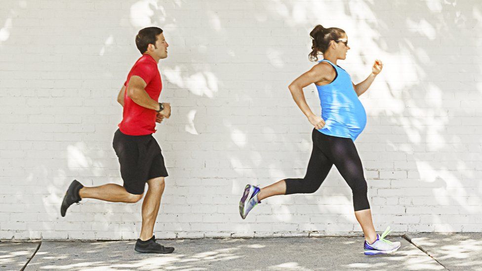 A man and a pregnant woman training