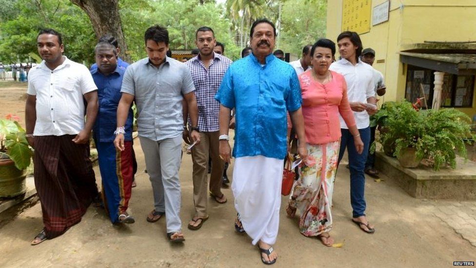 Former President Mahinda Rajapaksa (third on the right) arrives at a polling station during the general election in Medamulana (17 August 2015)