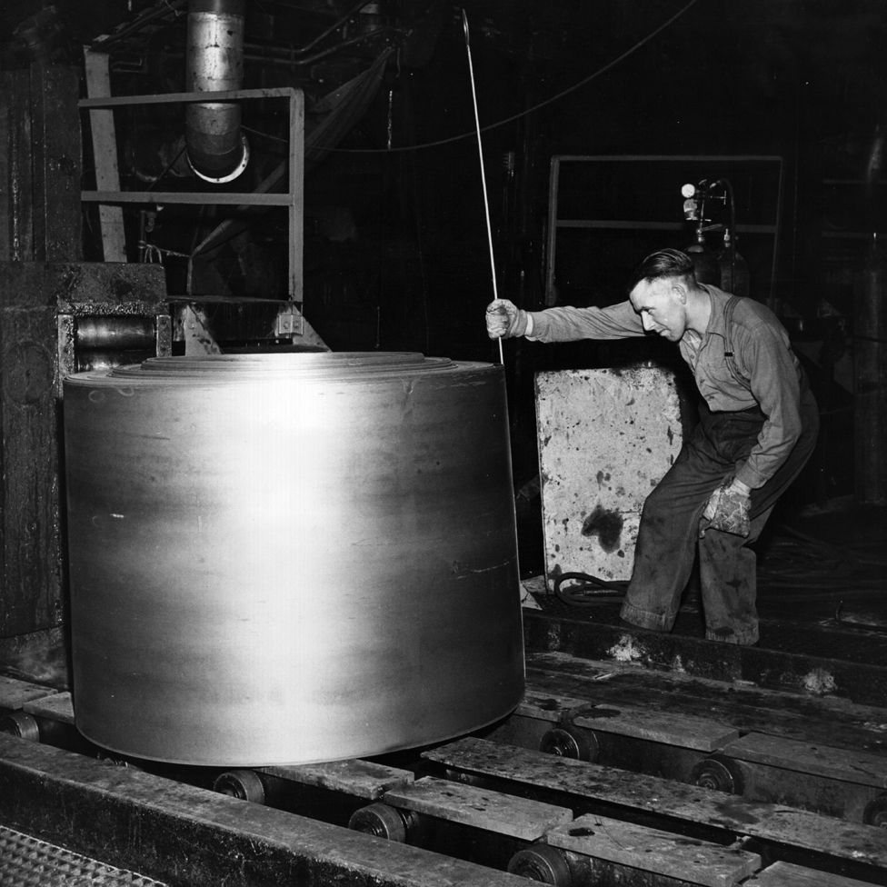 An employee at Abbey Steelworks, Port Talbot, measures a roll of steel, 1961