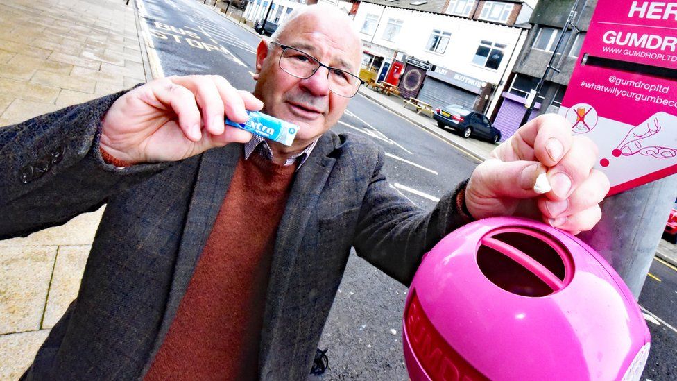 Middlesbrough Council's executive member for environment Dennis McCabe drops gum in pink bin