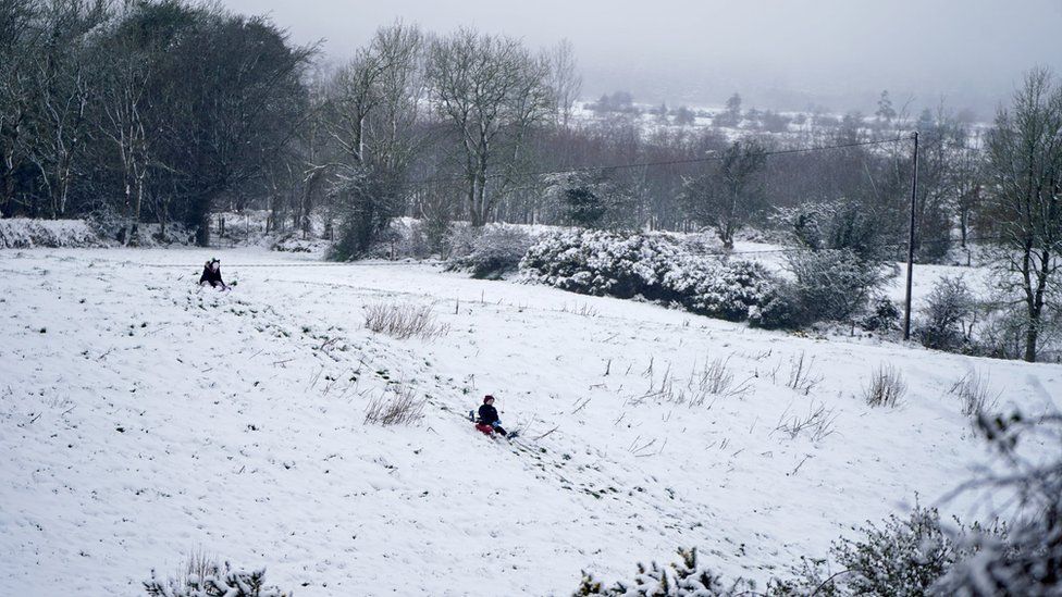 Children ride toboggans down a hill after heavy snow fall in Balboa, in Co Carlow.