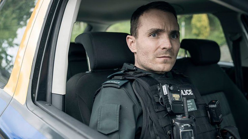 Martin McCann portraying officer Stevie Neil