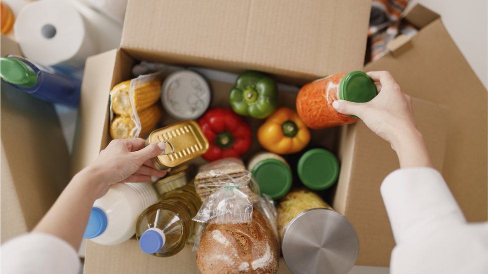 A box of food with a person pulling out items