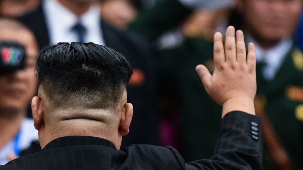 North Korea's leader Kim Jong Un (L) waves as he arrives to board his his train at the Dong Dang railway station in Lang Son on March 2, 2019.
