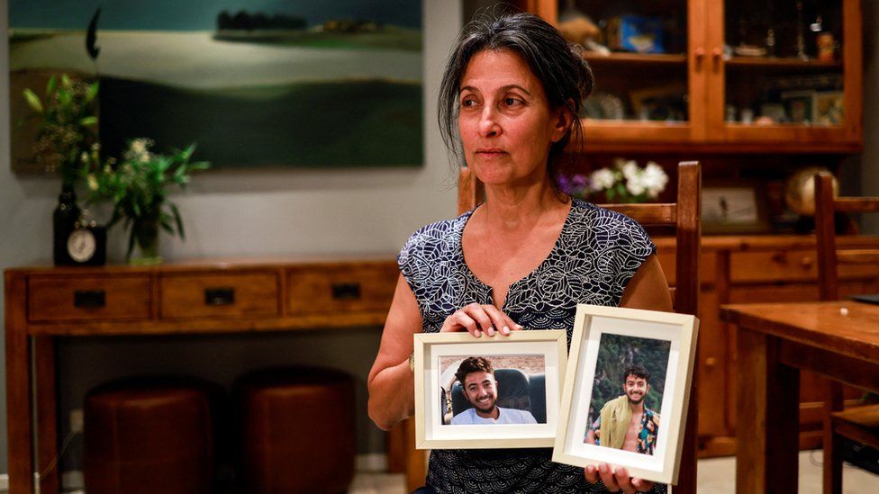 Rachael Goldberg-Polin holding pictures of her son