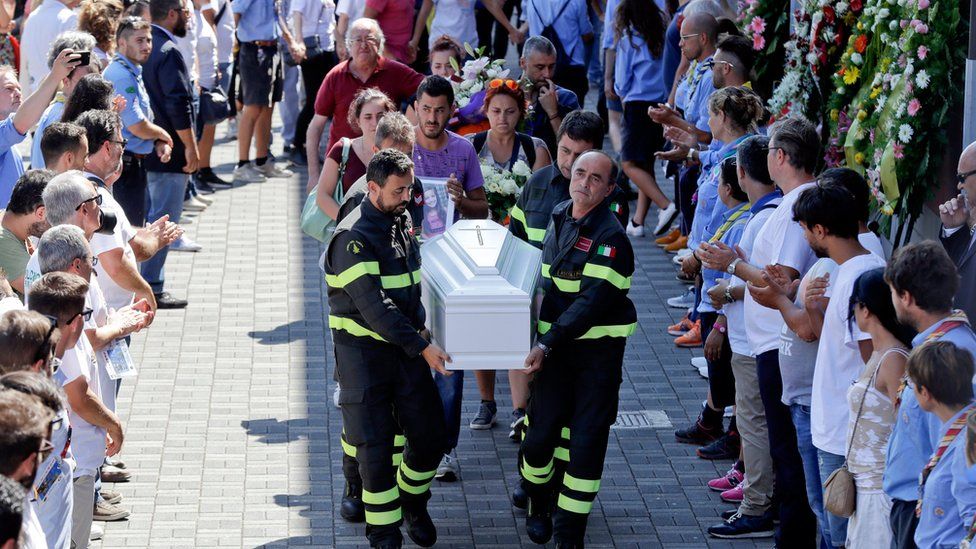 Firefighters carry Giulia's coffin