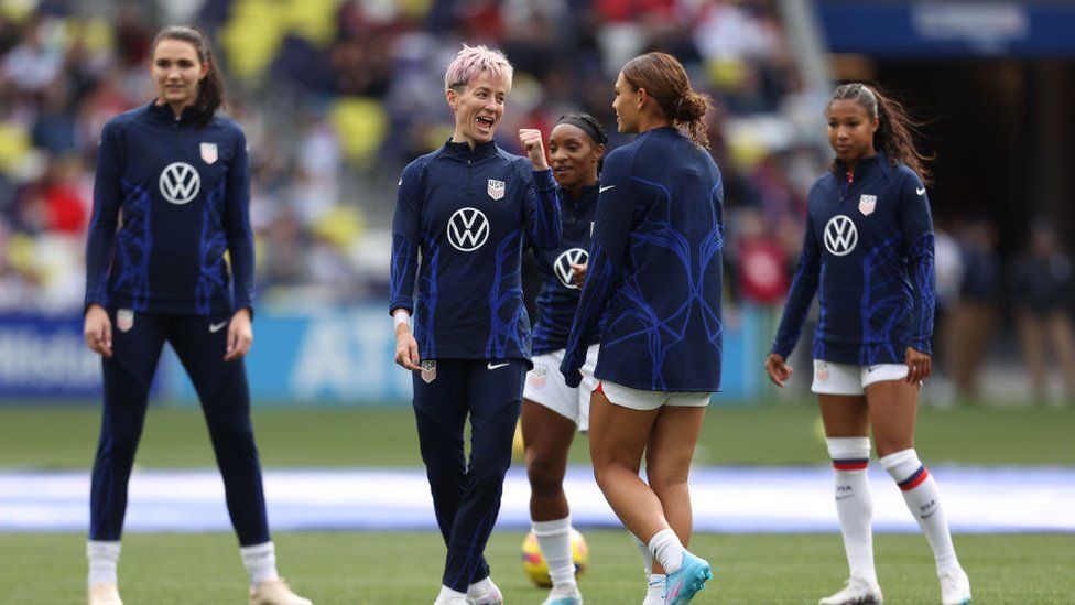 Five female footballers warming up on the pitch