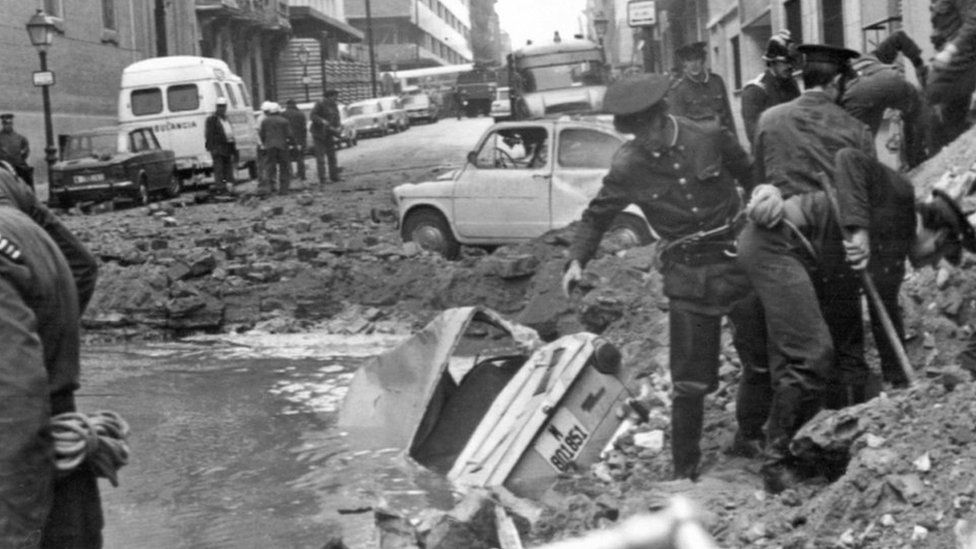 Spanish policemen search among the damage caused by a bomb attack, 20 December 1973, in which Spanish Prime Minister Luis Carrero Blanco was killed