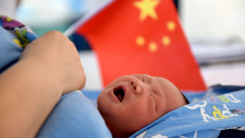 Chinese baby in front of Chinese flag