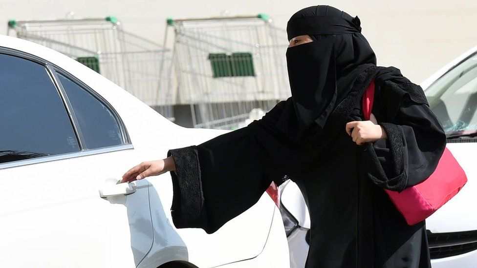 A Saudi woman wearing a Niqab gets into a taxi at a mall in Riyadh as a grassroots campaign planned to call for an end to the driving ban for women in Saudi Arabia on October 26, 2014